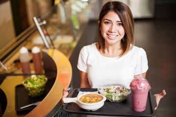 Cute woman with a tray of healthy food in a restaurant