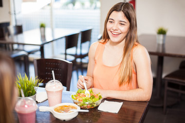 Obraz na płótnie Canvas Two girls eating at a restaurant