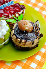 Cakes with berries on a green plate.