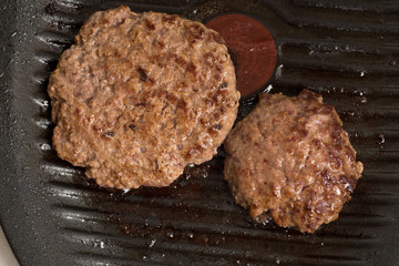 Fresh meat cutlets in a frying pan grill