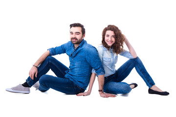 Fototapeta na wymiar happy young couple sitting on the floor isolated on white