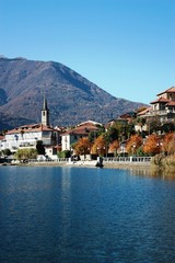 Fototapeta premium View to Mergozzo waterfront and Chiesa di Maria Vergine Assunta under blue sky, Italy 