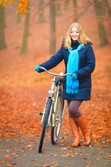 Fototapeta premium Happy active woman riding bike in autumn park.