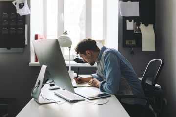 Young graphic designer working in office