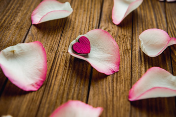 Close-up image of red rose petals on a wooden background