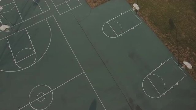 Teen boy taking shots on basketball court.