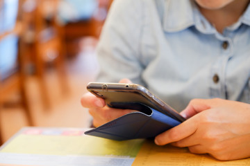 Fototapeta premium Close up woman using mobile phone at restaurant, Digital lifesty