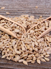 Sunflower seeds with spoon on wooden background