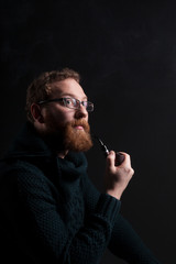 A man with a red beard with a pipe