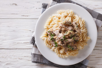 beef stroganoff with pasta fusilli . Horizontal top view 