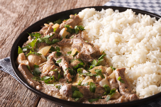 beef stroganoff garnished with rice close-up on a plate. horizontal
