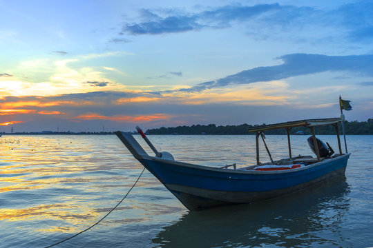 Wooden fisherman boat with sunset background