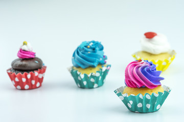 Vanilla cupcakes with buttercream icing and various decorations.