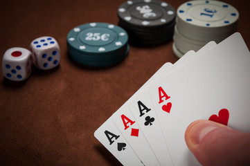 Chips and cards for poker in hand on table