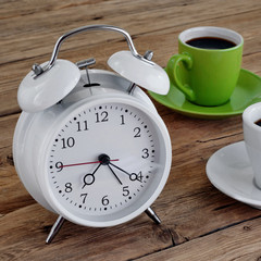 Two cups of espresso with an alarm clock