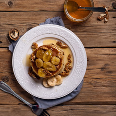 Golden pancake with caramelized bananas, honey and nuts