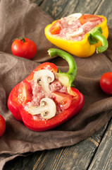 Raw stuffed peppers with minced meat, mushrooms and cherry tomat