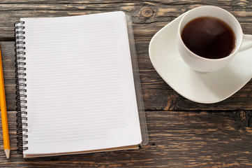 open notebook with blank pages, pencil and cup tea