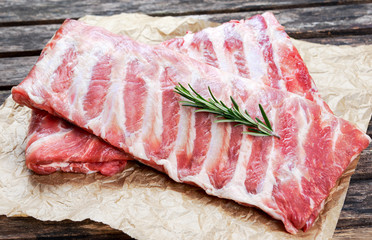 Raw Pork ribs with a rosemary. on crumpled paper