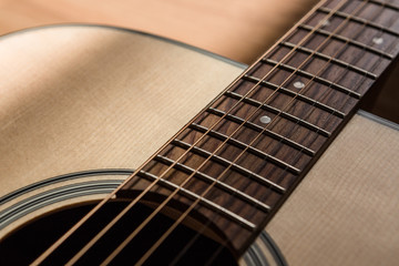 Obraz premium part of guitar sound hole with string on blurred wood background