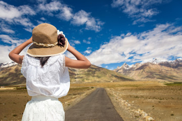 Fototapeta na wymiar Back of traveller girl with a road to Zanskar Valley in sunny da