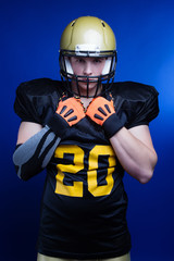 A player in american football with helmet on his head standing on blue background.