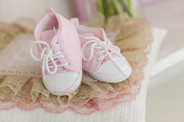 Waiting for the baby. Pink baby shoes.