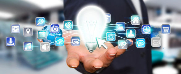 Businessman holding lightbulb with digital icons