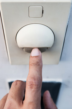 A finger is turning on a light switch.