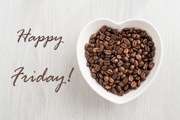 Happy Friday note and coffee bean in a bowl in the form of heart