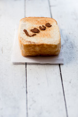 Love message on Bread sliced on white wooden background.