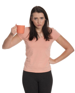 Junge Frau h&auml;lt eine Kaffeetasse und schaut brummig