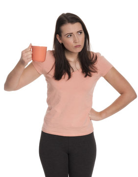 Junge Frau hält eine Tasse Kaffee und schaut böse 