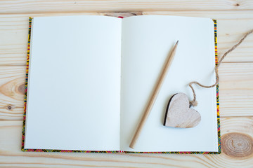 notebook and pencil on wooden background
