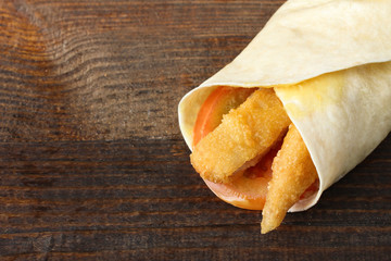 Wrap with grilled chicken and vegetables on brown wood table