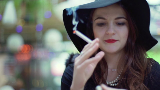 Glamorous woman fire the cigarette and smoking it
