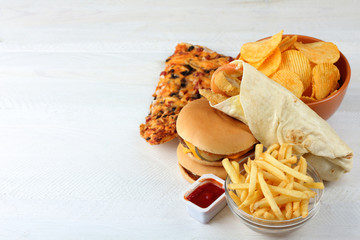 Big appetizing hamburger with chips isolated on white wood table