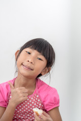 Asian girl eating bread at home.