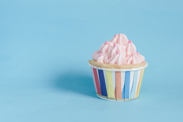 Pearl birthday cupcake with butter cream icing on blue pastel ba