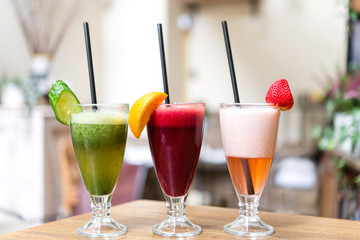 Assorted three fresh smoothies on wooden table