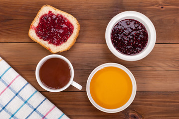 Cup of tea bread with jam and honey on a wooden table. Top view .