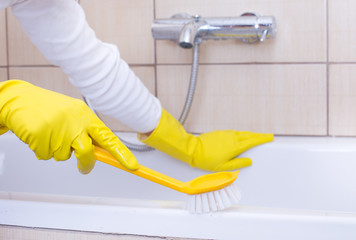 Woman cleaning bathtub
