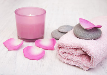 Obraz na płótnie Canvas Bath towels and candle with pink roses