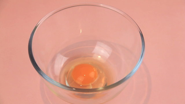 Cracking two eggs into a bowl and whisking briskly.