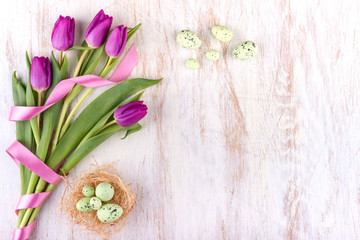 easter eggs and flowers over white wooden table