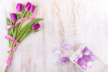 easter eggs and flowers over white wooden table
