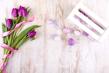 easter eggs and flowers over white wooden table