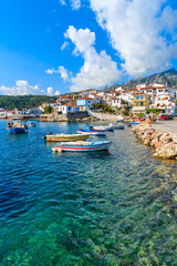 Fototapeta na wymiar Fishing boats in Kokkari port with colourful Greek houses, Samos island, Greece