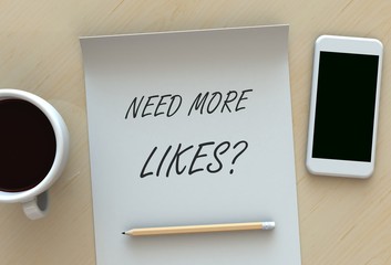 Need More Likes, message on paper, smart phone and coffee on table