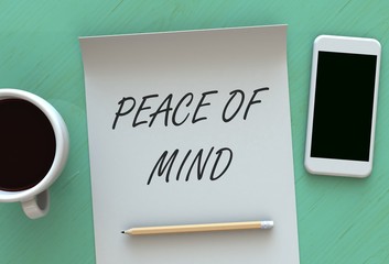 Peace of Mind, message on paper, smart phone and coffee on table